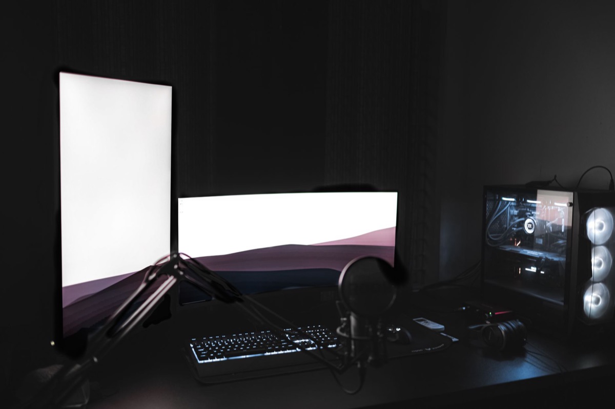 gaming PC setup in dark room with RGB lighting and minimalist backdrop