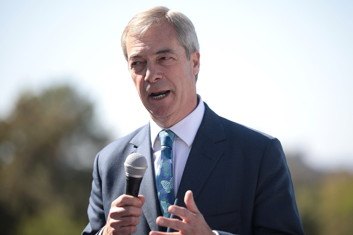 Nigel Farage speaking at political event with audience in background