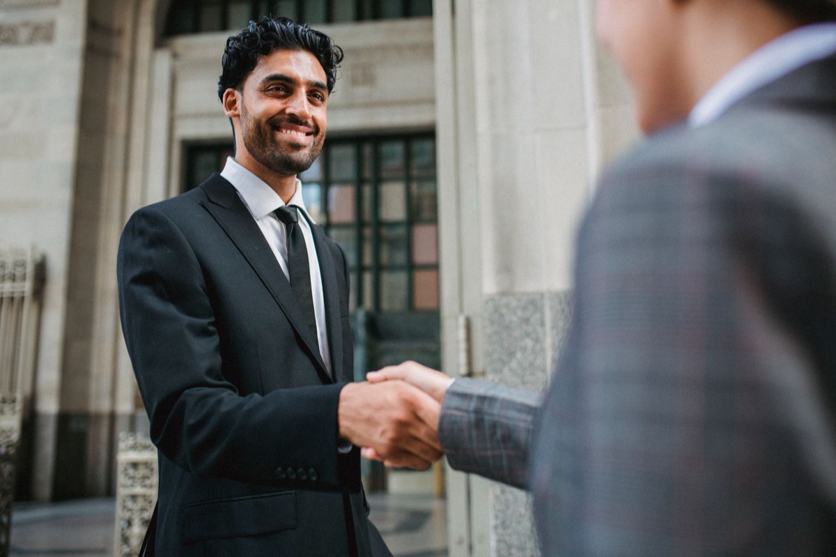 Two officials from UK and EU shaking hands at a formal meeting